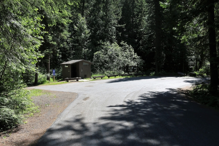 A picture of the vault style outhouse and welcome signs at the entrance to Giant White Pine Campground.