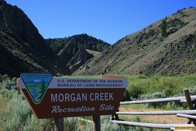 The sign at the entrance to Morgan Creek Recreation Site and view of nearby mountains.