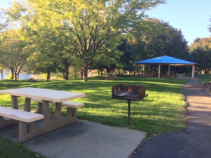 A picture of a picnic site in the day use area of Woodhead Park with the group shelter in the background.