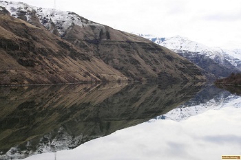 picture of mountains reflecting on oxbow reservoir in hells canyon